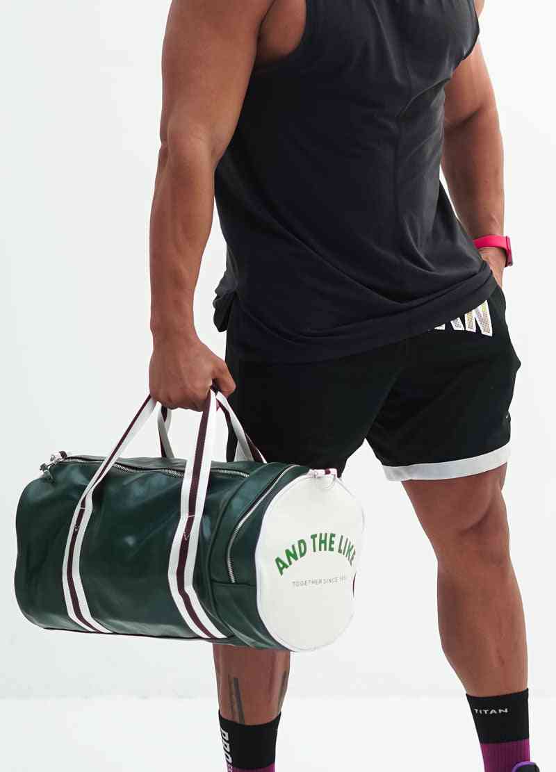 a man holding a duffel bag and a tennis racquet